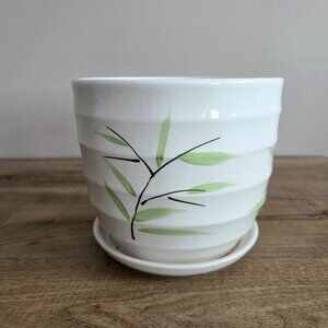 Ceramic planter/cover pot with attached saucer.
